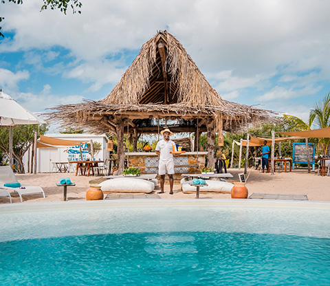 Beautiful Pool side view of Peri Peri Beach Club a waiter holding a tray of drinks