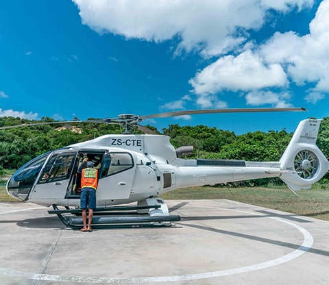 Helicopter on the helio pad with a man standing outside 